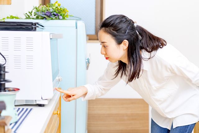 電子レンジを操作する女性
