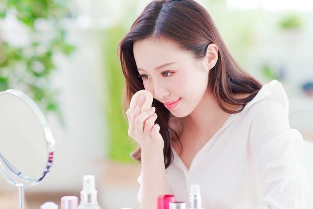鏡を見ながらメイクを楽しむ女性